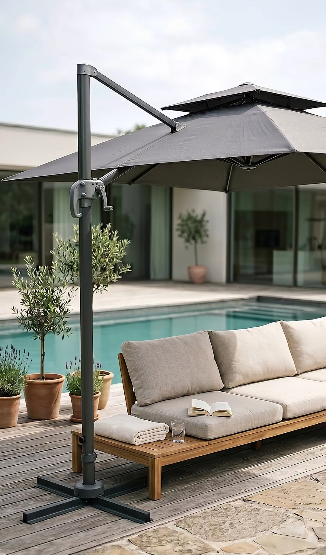 Parasol déporté anthracite Levant Ombralys ouvert au bord d'une piscine, toile double toit anti-vent